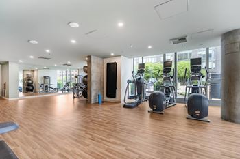 Fitness studio with cardio equipment and wooden flooring